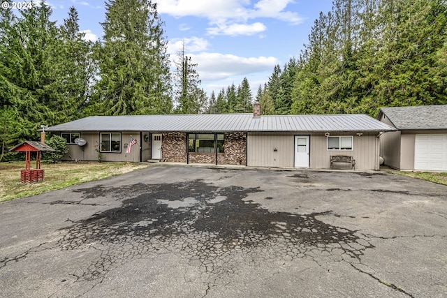 ranch-style house featuring aphalt driveway and a chimney