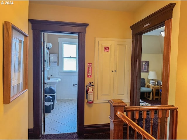 corridor featuring tile patterned flooring and tile walls