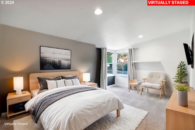 bedroom with carpet floors and lofted ceiling