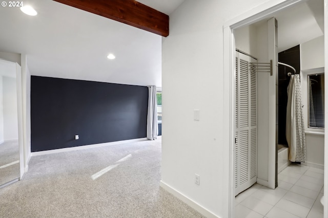 interior space with beamed ceiling and light carpet