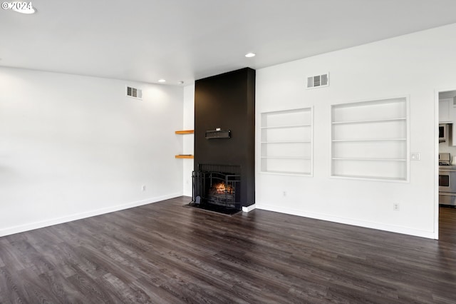 unfurnished living room with dark hardwood / wood-style floors and built in features