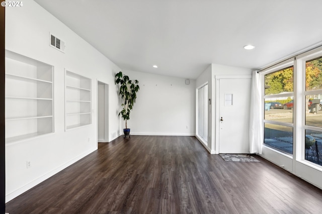 unfurnished room featuring dark hardwood / wood-style flooring and built in features