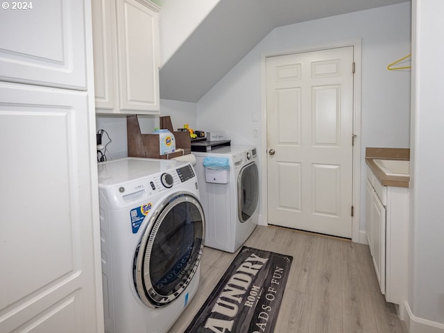 clothes washing area with independent washer and dryer, cabinets, and light hardwood / wood-style floors