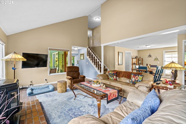 living room with lofted ceiling and a wood stove