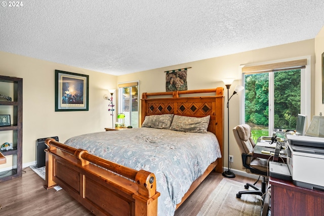 bedroom with a textured ceiling and dark wood-type flooring