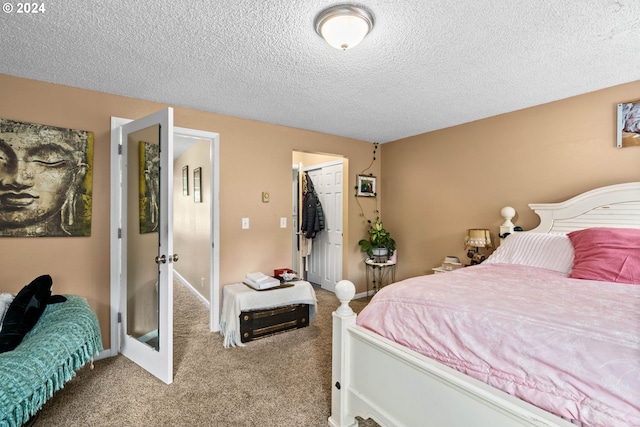 bedroom featuring a textured ceiling, a spacious closet, a closet, and carpet flooring