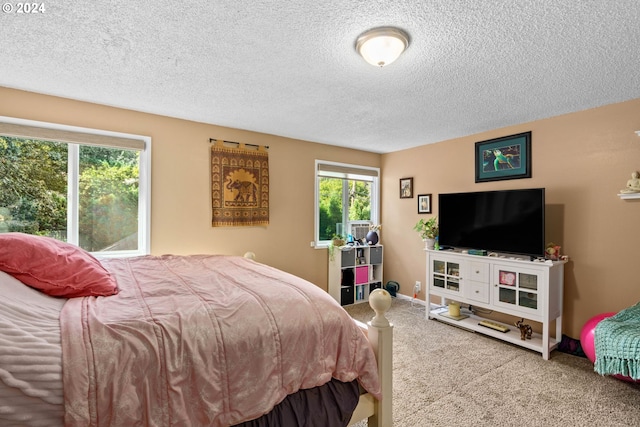 carpeted bedroom featuring a textured ceiling and multiple windows