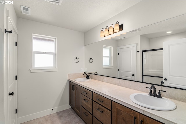 full bath featuring a healthy amount of sunlight, visible vents, and a sink