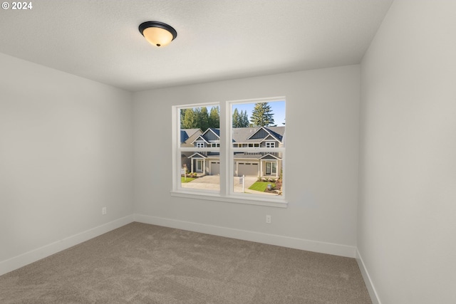 carpeted empty room featuring baseboards