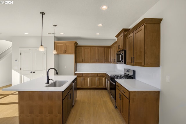 kitchen with light countertops, appliances with stainless steel finishes, a sink, and brown cabinets