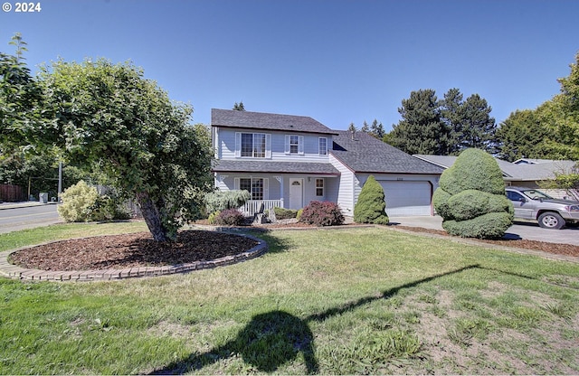 view of front of home with covered porch, a garage, and a front lawn