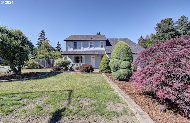 back of property featuring a lawn and covered porch