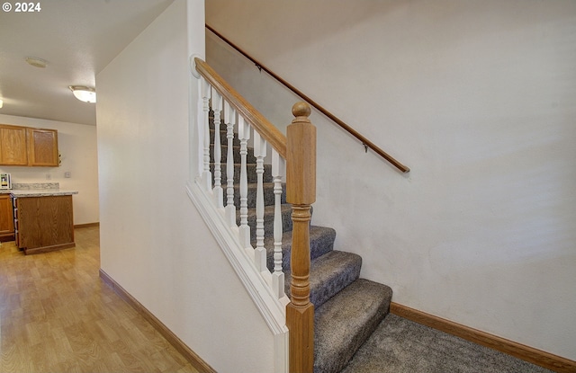 staircase with hardwood / wood-style floors