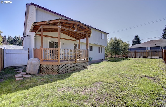 back of property featuring a lawn and a deck