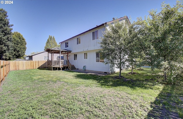 rear view of house with a gazebo, a yard, and a wooden deck