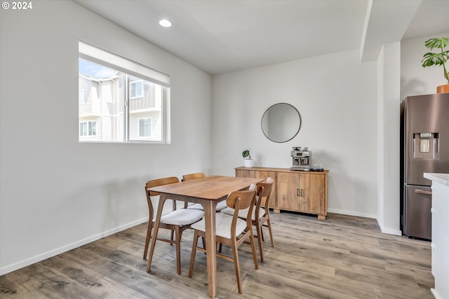 dining room with recessed lighting, light wood-style flooring, and baseboards