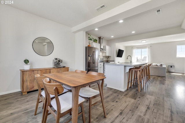 dining area featuring baseboards, visible vents, wood finished floors, and recessed lighting