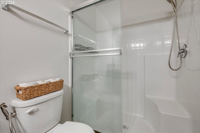 bathroom with an enclosed shower and toilet