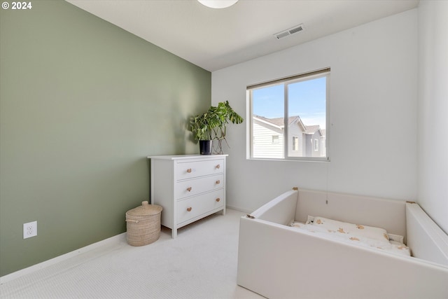 bedroom featuring visible vents and light carpet