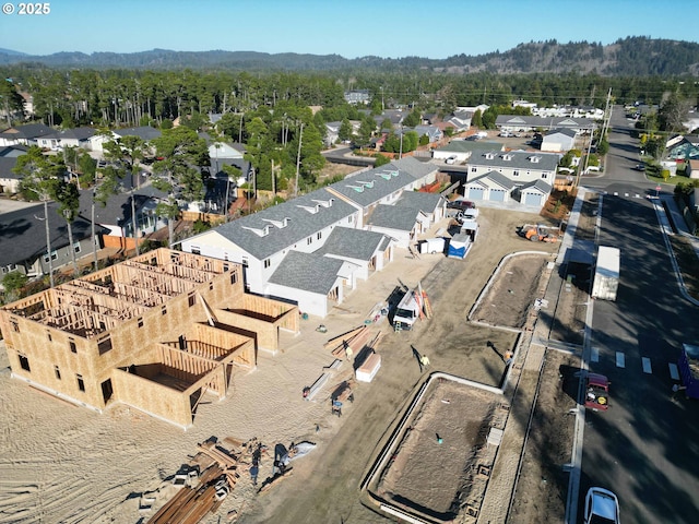 drone / aerial view featuring a wooded view and a residential view