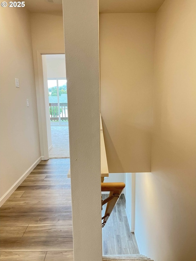 staircase with baseboards and wood finished floors