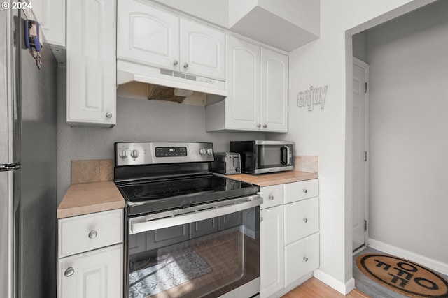 kitchen featuring stainless steel appliances, white cabinetry, and light wood-type flooring