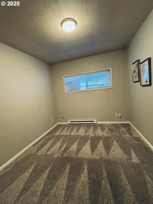 carpeted empty room featuring baseboard heating and a textured ceiling