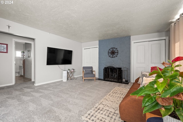 living room featuring a large fireplace, light colored carpet, and a textured ceiling