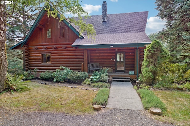 log cabin featuring a front yard and a porch