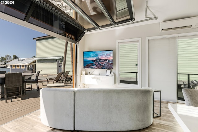 living room featuring light wood-type flooring and an AC wall unit