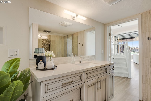 535 NE Bridgeton Rd Unit 7, Portland, OR 97211 - bathroom with vanity, tasteful backsplash, wood finished floors, and a textured ceiling
