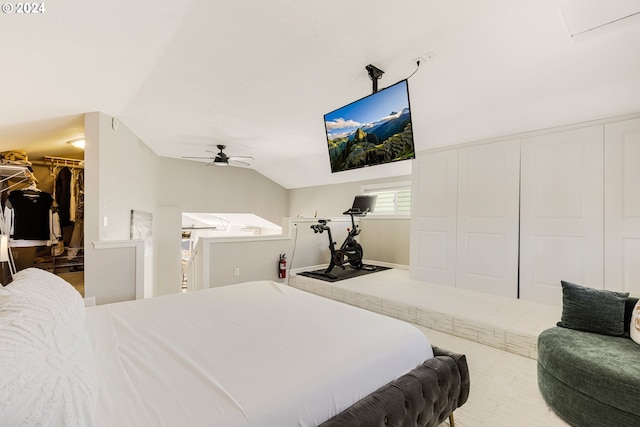 bedroom with ceiling fan, a closet, a walk in closet, and vaulted ceiling