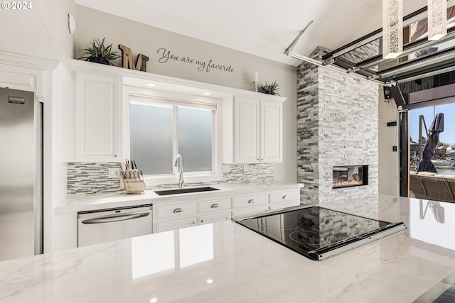 535 NE Bridgeton Rd Unit 7, Portland, OR 97211 - kitchen with stainless steel appliances, a sink, decorative backsplash, and white cabinetry