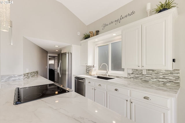 535 NE Bridgeton Rd Unit 7, Portland, OR 97211 - kitchen featuring stainless steel appliances, a sink, decorative backsplash, white cabinets, and high vaulted ceiling