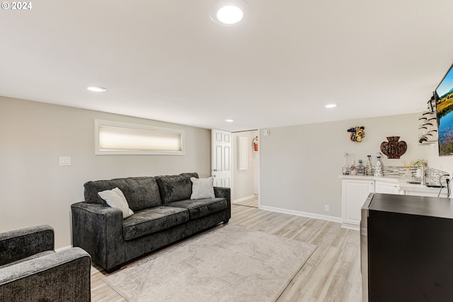 living room with light hardwood / wood-style flooring and sink