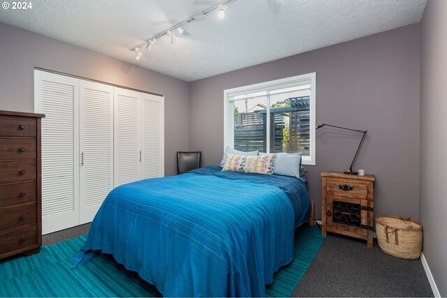 bedroom with a textured ceiling and a closet