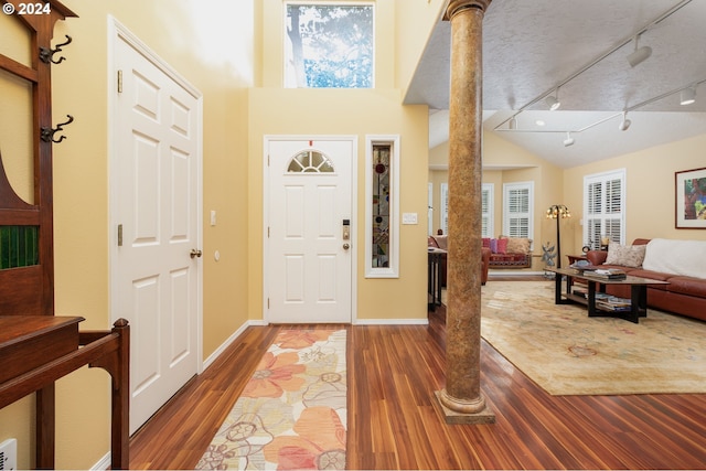 entryway featuring a towering ceiling, a textured ceiling, hardwood / wood-style flooring, and track lighting