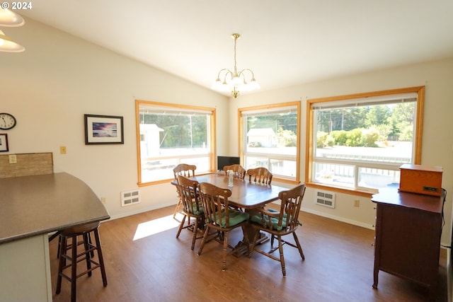 dining area featuring dark wood-type flooring, a healthy amount of sunlight, lofted ceiling, and a notable chandelier