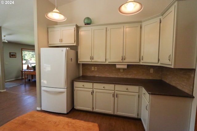 kitchen featuring hardwood / wood-style floors, white cabinets, backsplash, hanging light fixtures, and white fridge