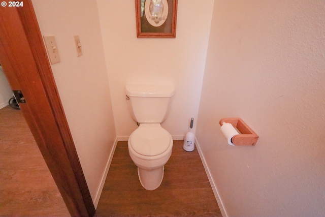 bathroom featuring wood-type flooring and toilet