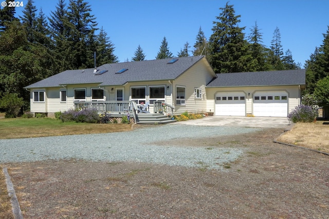 ranch-style house featuring a garage, a deck, and a front lawn