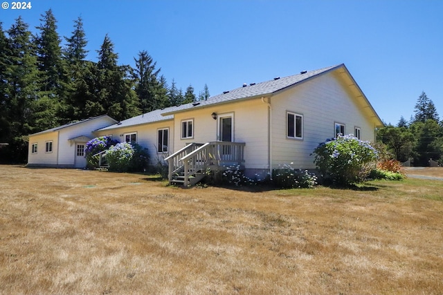 rear view of property featuring a lawn