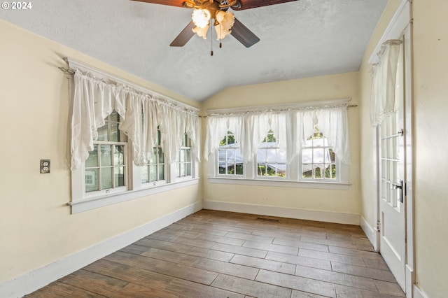 unfurnished sunroom with ceiling fan and lofted ceiling