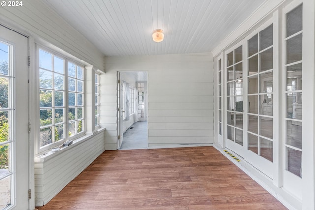 unfurnished sunroom with wood ceiling and a healthy amount of sunlight