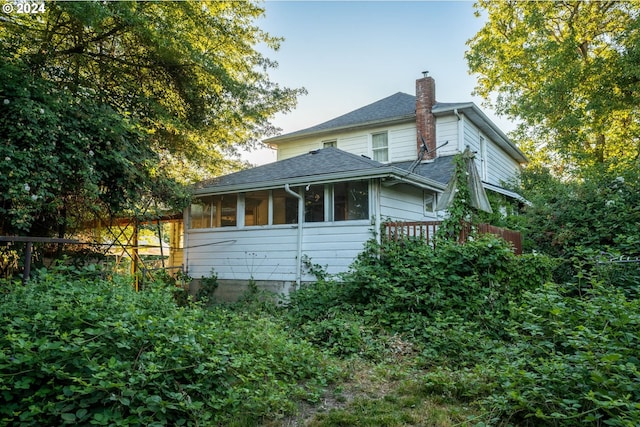 view of property exterior featuring a sunroom