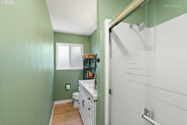 bathroom featuring vanity, toilet, wood-type flooring, and walk in shower