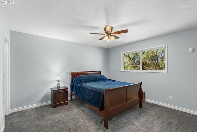 bedroom with a textured ceiling, dark carpet, and ceiling fan