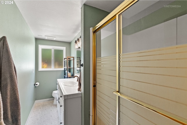 bathroom featuring walk in shower, vanity, and toilet