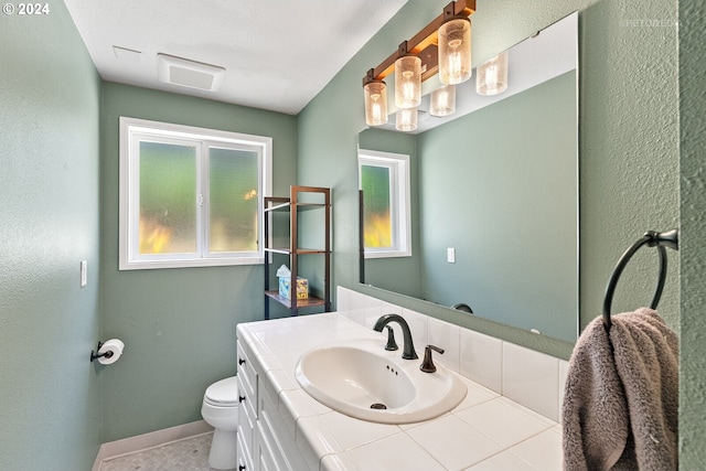 bathroom featuring tile patterned flooring, vanity, and toilet