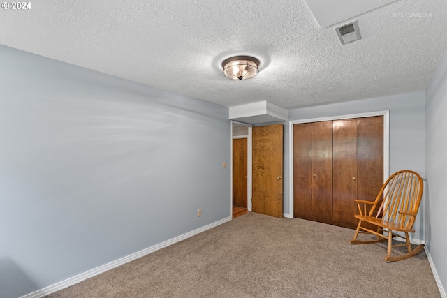 unfurnished bedroom featuring carpet flooring, a textured ceiling, and a closet